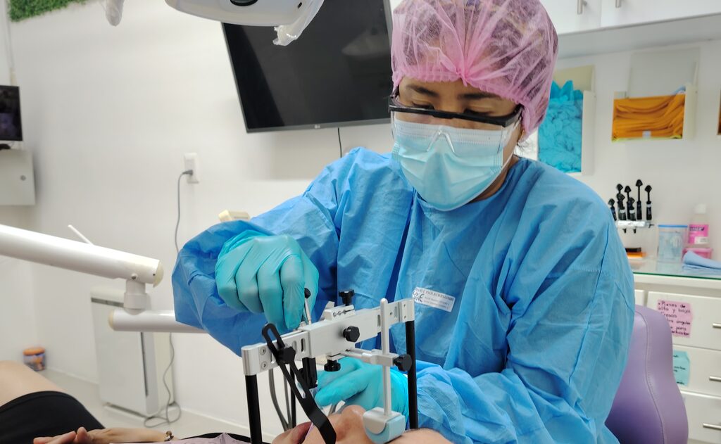 Profesional de KineDenta realizando un registro con arco facial, parte del estudio de la articulación temporomandibular
